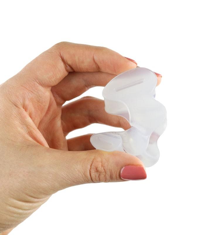 Hand squeezing a Correct Toes toe spreader, showing the softness and flexibility