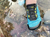close-up of foot wearing Aqua X Sport in surf in shallow water, being careful not to step on a sea star