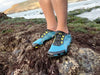 feet wearing Aqua X Sport in surf while standing on wet rocks and moss