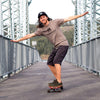 Coasting on a Skateboard on a bridge wearing Lems Chillum Minimal Shoes