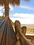 Person wears Nomadic State Rope Sandals in Camel while relaxing in a hammock