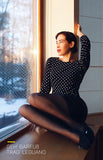 person modelling the Leguano Lady Loop while sitting on a wide windowsill looking at the trees
