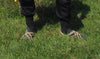 Person wearing Nomadic State Rope Sandals with socks in the grass